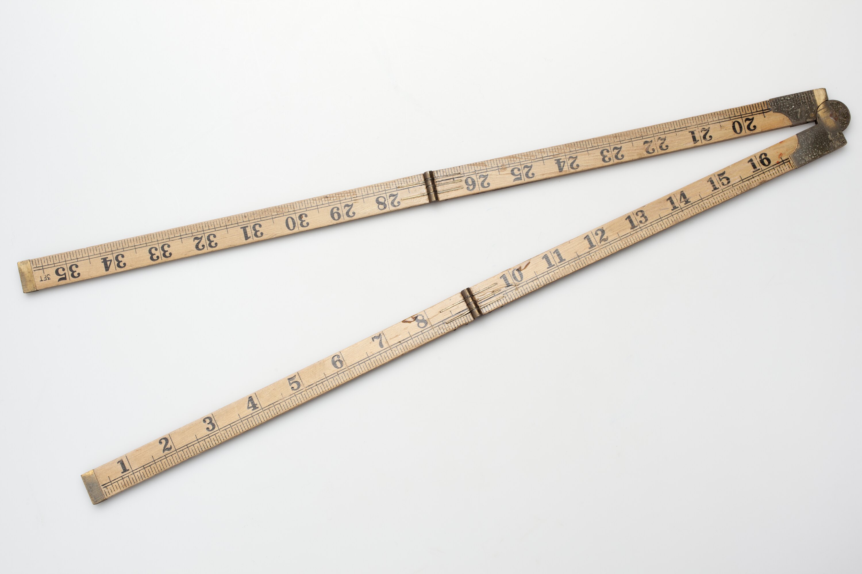 A wooden carpenter's folding yard rule with brass hinges, opened out